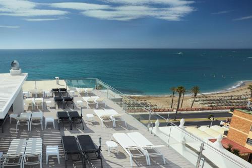 a balcony with chairs and the beach and the ocean at Hotel Las Arenas, Affiliated by Melia in Benalmádena