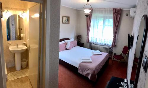 um quarto com uma cama, um lavatório e um espelho em Pension Hotel Fast em Rădăuţi