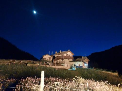 an old house on top of a hill at night at la casa dei nonni in Valtournenche