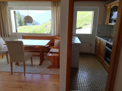 Inden的住宿－Chalet Waldrand，厨房以及带桌子和窗户的用餐室。