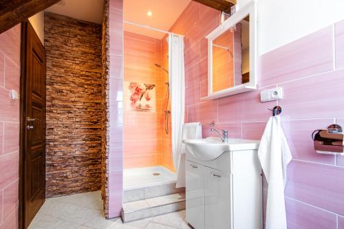 a pink bathroom with a sink and a shower at Penzion Zlaté Slunce in Chocenice