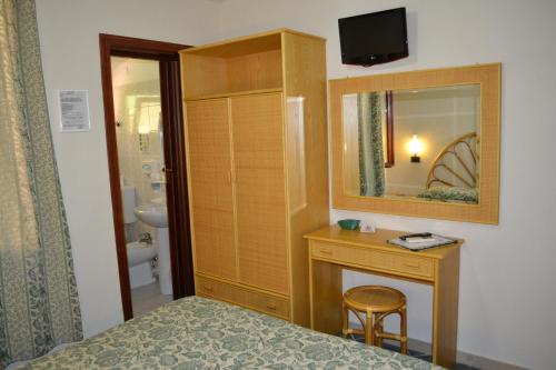 a bedroom with a bed and a vanity and a mirror at Hotel Danila in Portoferraio