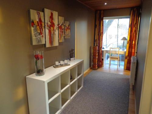 a living room with a white cabinet and a table at Green Hill Apartment Overijse in Overijse