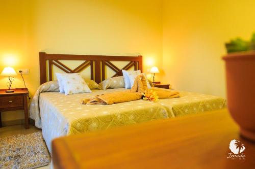 a bedroom with a bed with yellow walls at Hotel Rural Imada in Imada