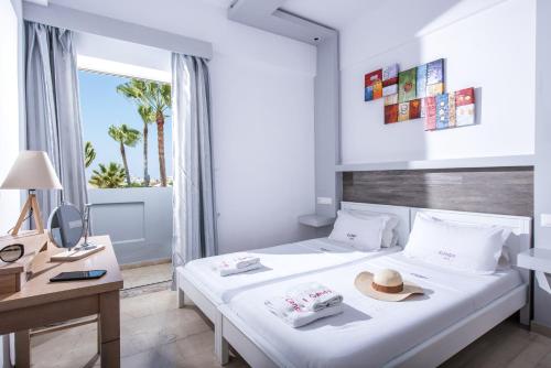 a bedroom with a bed with a hat on it at I Candy Malia by Estia in Malia