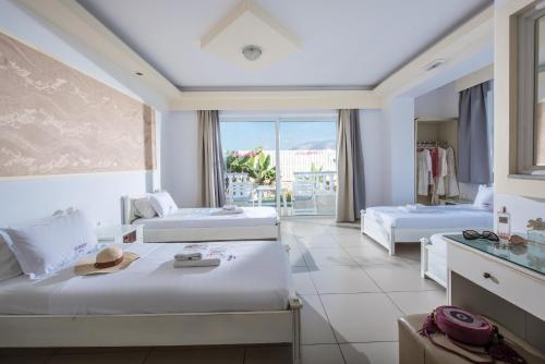 a hotel room with two beds and a window at I Candy Malia by Estia in Malia