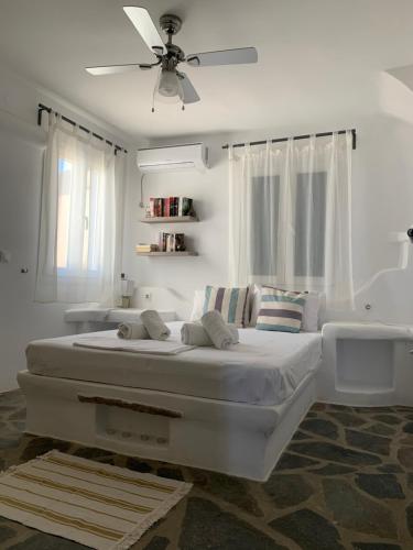 Agios RomanosにあるSea and Sun Villaのベッドルーム(大きな白いベッド、天井ファン付)