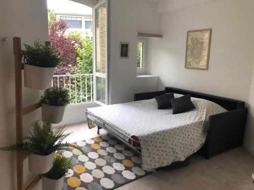una camera con letto e un balcone con piante di Les Appartements Chambon a Sarlat-la-Canéda