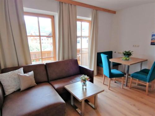 a living room with a couch and a table and chairs at Der Bachwirt in Maria Alm am Steinernen Meer