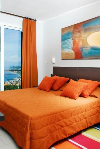 a bed with orange pillows in a room with a window at Residence Villa Beuca in Cogoleto