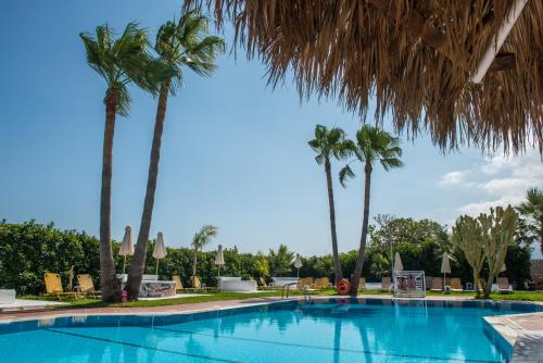 a swimming pool with palm trees in a resort at I Candy Malia by Estia in Malia
