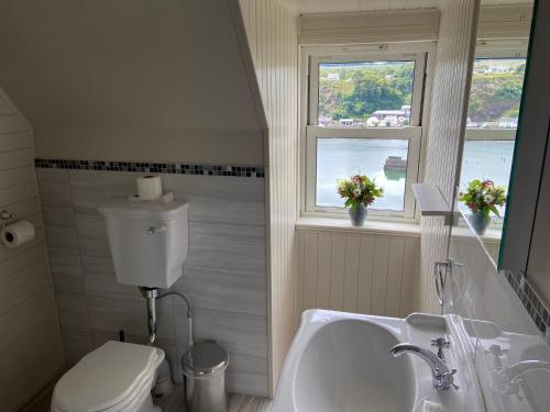 a bathroom with a sink and a toilet and a window at Western Isles Hotel in Tobermory