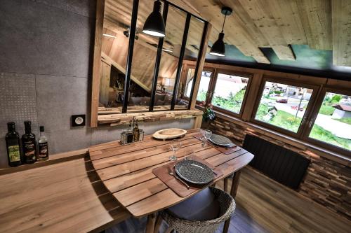 a wooden table in a room with windows at Studio Lessy - Centre village - AravisTour in Saint-Jean-de-Sixt