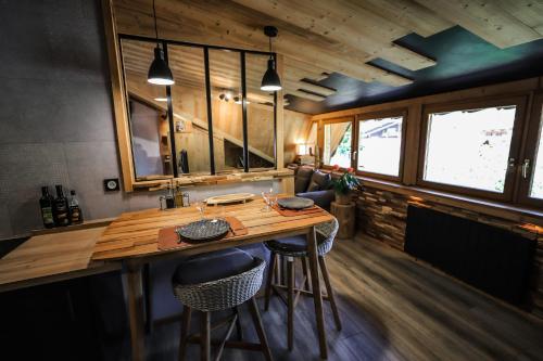 - une cuisine avec une table en bois et des tabourets dans la chambre dans l'établissement Studio Lessy - Centre village - AravisTour, à Saint-Jean-de-Sixt