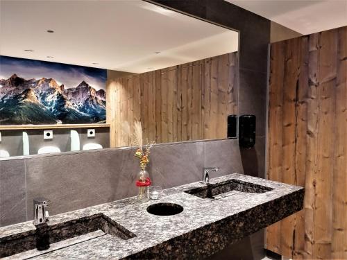 a bathroom with a sink and a large mirror at Der Bachwirt in Maria Alm am Steinernen Meer