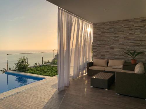a living room with a couch and a view of the ocean at Holiday Apartment Sunset Ocean in Ribeira Brava
