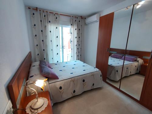 モトリルにあるBonito Apartamento Vacacionalの小さなベッドルーム(ベッド1台、鏡付)