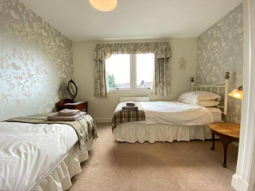 a bedroom with two beds and a window at St Margaret's Cottage, Edinburgh in Edinburgh
