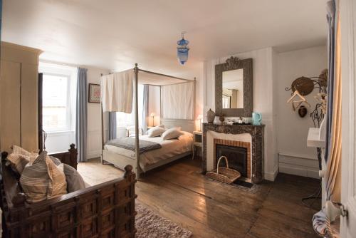 sypialnia z łóżkiem, kominkiem i lustrem w obiekcie Les Chambres de Lourmel w mieście Pontivy