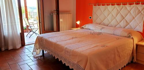 a bedroom with a large bed with a orange wall at Casina di Pacina in Abbadia di Montepulciano