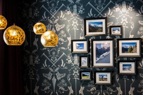 a group of framed pictures on a wall with lights at Pointe Isabelle in Chamonix-Mont-Blanc