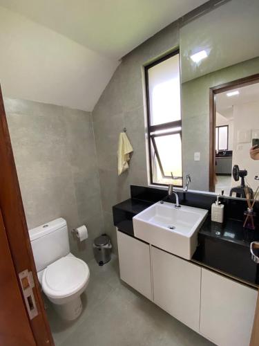 a bathroom with a white toilet and a sink at Villas de Bananeiras in Bananeiras