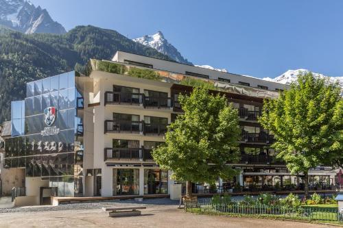 a large building with mountains in the background at Pointe Isabelle in Chamonix