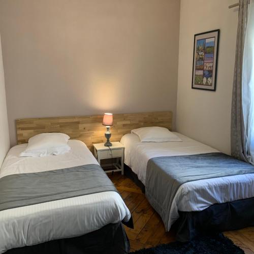 une chambre avec deux lits et une lampe sur une table dans l'établissement Private house with a view on Bayeux's Cathedrale, à Bayeux