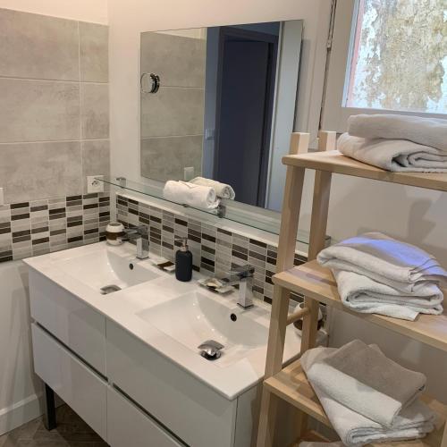 une salle de bain avec un lavabo, un miroir et des serviettes dans l'établissement Private house with a view on Bayeux's Cathedrale, à Bayeux