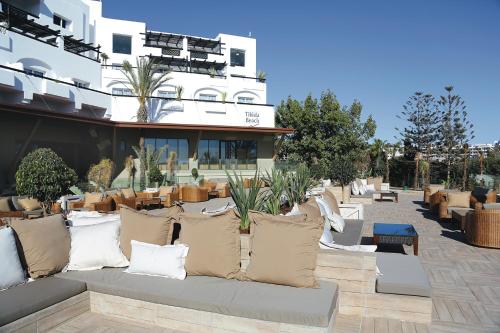 a patio with pillows on a couch in front of a building at Hotel Riu Tikida Beach - Adults Only - All inclusive in Agadir