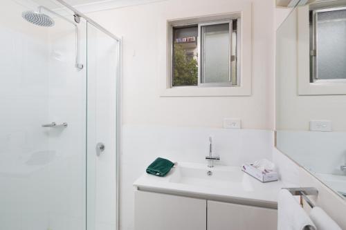 a white bathroom with a sink and a shower at Bayview Apartments by Classic Holidays in Cowes