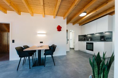 a kitchen and dining room with a table and chairs at Moderne 3 Zi.-FeWo BlackForestArt Nähe Freiburg in Simonswald