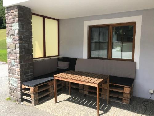 einer Bank und einem Tisch vor einem Fenster in der Unterkunft Haus Elvira in Klösterle am Arlberg