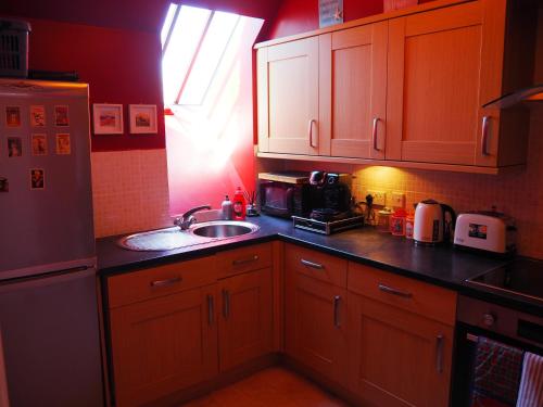 a kitchen with wooden cabinets and a sink and a window at The Snug @ the Mill Inn, Stonehaven in Stonehaven