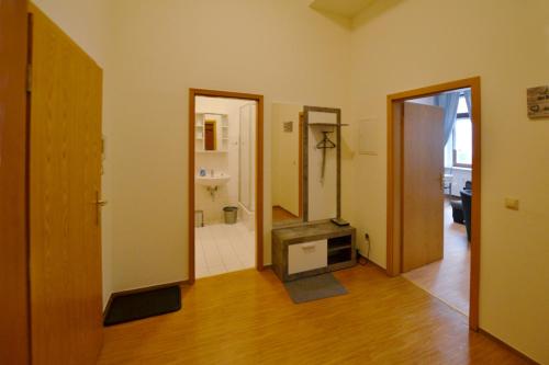 ein Wohnzimmer mit einem TV und einem Badezimmer in der Unterkunft FeWo der 'Villa Ephraim' - James-von-Moltke-Str. in Görlitz