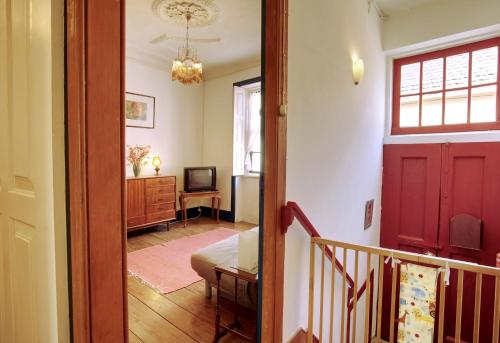 a hallway with a red door and a living room at Casa do Mestrinho in Avintes