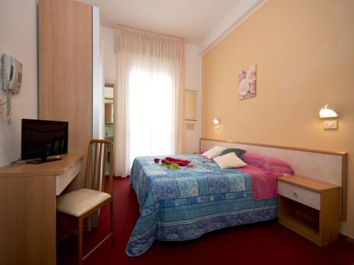 a bedroom with a bed and a desk and a television at Villa Silvie Rose in Cesenatico