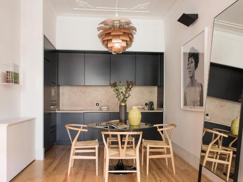 a kitchen with a dining room table and chairs at Madalena Orquidea Living Apartments in Lisbon