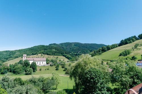 a house on a hill in a field with trees at Moderne 3 Zi.-FeWo BlackForestArt Nähe Freiburg in Simonswald