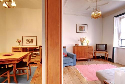 a living room with a table and a dining room at Casa do Mestrinho in Avintes