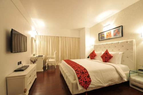 a hotel room with a large bed and a desk at The Fern Residency Rajkot in Rajkot