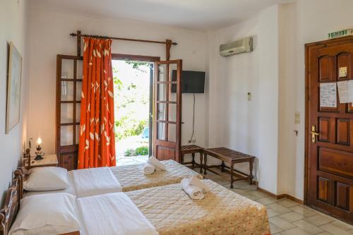 um quarto com uma cama e uma porta de vidro deslizante em Pandora Studios Skiathos em Skiathos