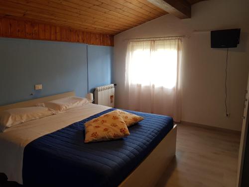 a bedroom with a bed with blue sheets and a window at Appartamenti Bice Abetone in Abetone