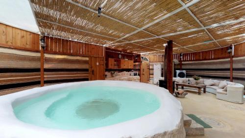 uma grande banheira no meio de um quarto em Shkutai Hottub Arava em Ẕofar
