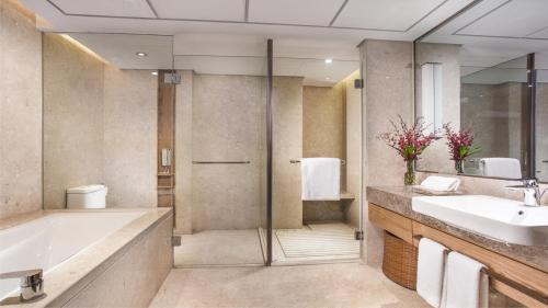 a bathroom with a tub and a sink and a shower at Holiday Inn Hefei by IHG in Hefei