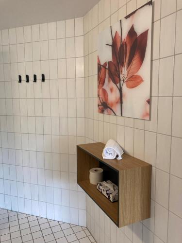a tiled bathroom with a shelf with a towel at Best Western Hotel Hillerød in Hillerød