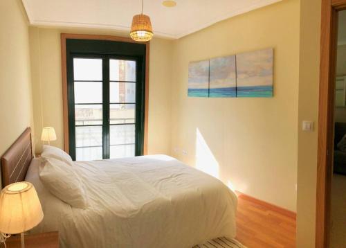 ein Schlafzimmer mit einem weißen Bett und einem Fenster in der Unterkunft The Cliffs - Espasante Nook in O Porto de Espasante