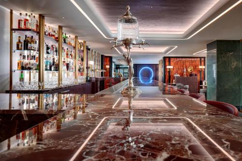 a bar in a hotel with a counter with drinks at Almanac X Alcron Prague in Prague