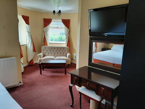 a hotel room with a bedroom with a bed and a mirror at Laggan Hotel in Laggan