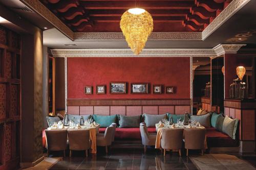 a dining room with tables and chairs and a chandelier at Hotel Riu Tikida Dunas - All inclusive in Agadir